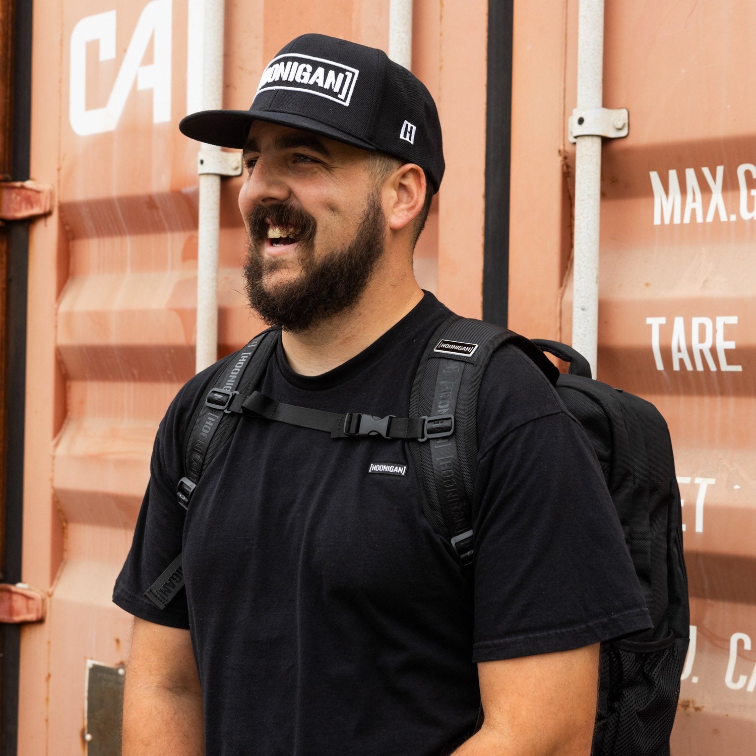 Hoonigan METAL BAR Backpack featuring a sleek black design and bold logo on the front. Ideal for urban use and outdoor adventures.