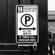 Hoonigan PARKING ONLY sign with bold black and white lettering on a weathered background.