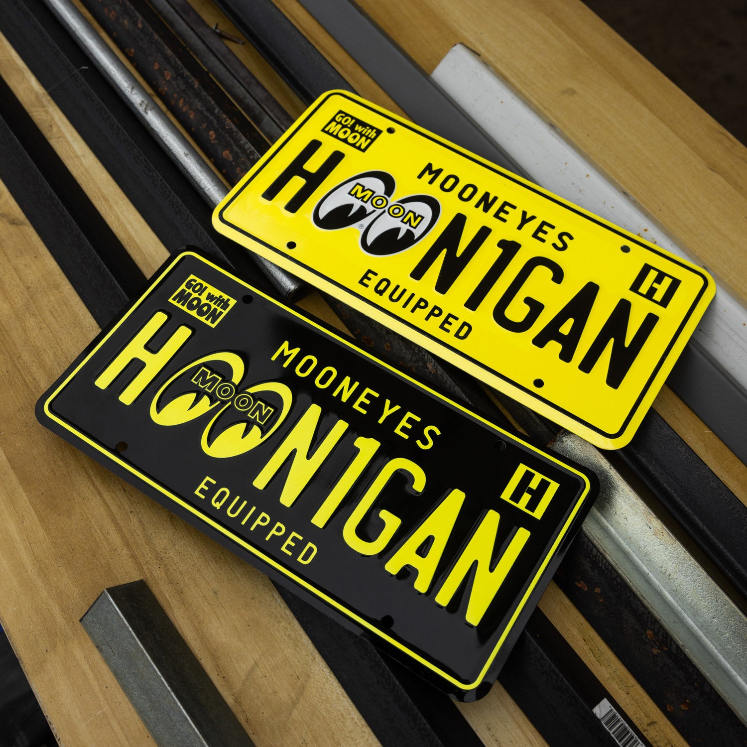 Hoonigan x Mooneyes EQUIPPED license plates in vibrant yellow and black, showcasing bold branding for car enthusiasts.