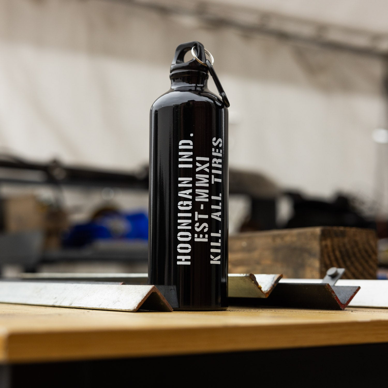 Hoonigan AMMO water bottle with a black body, bold white logo, and adjustable silicone sleeve, set against a clean background.