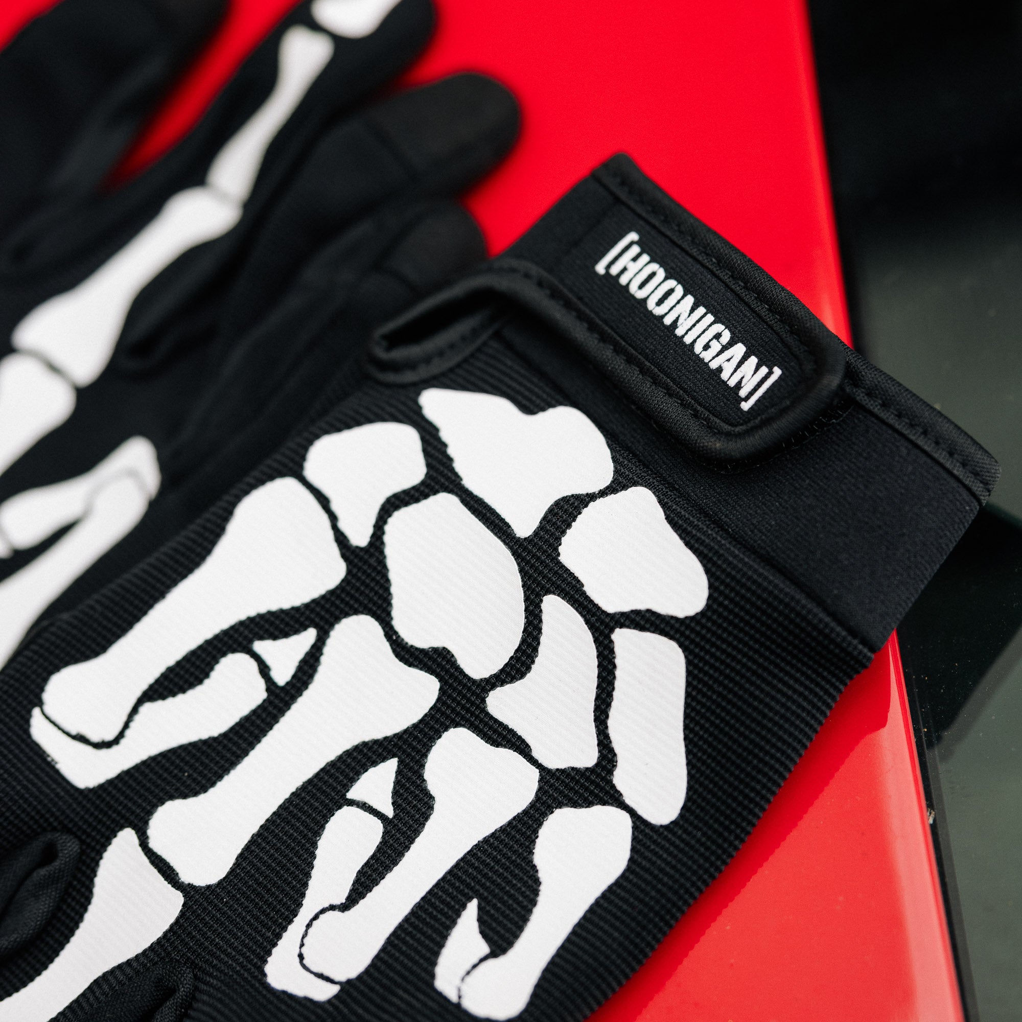 Hoonigan FIND OUT Gloves featuring a black and white design with a logo and reinforced palm for grip.