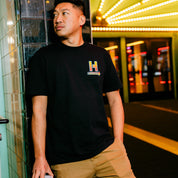 Hoonigan HOONCAPACITOR Short Sleeve Tee featuring a graphic design with vibrant colors on a black background.