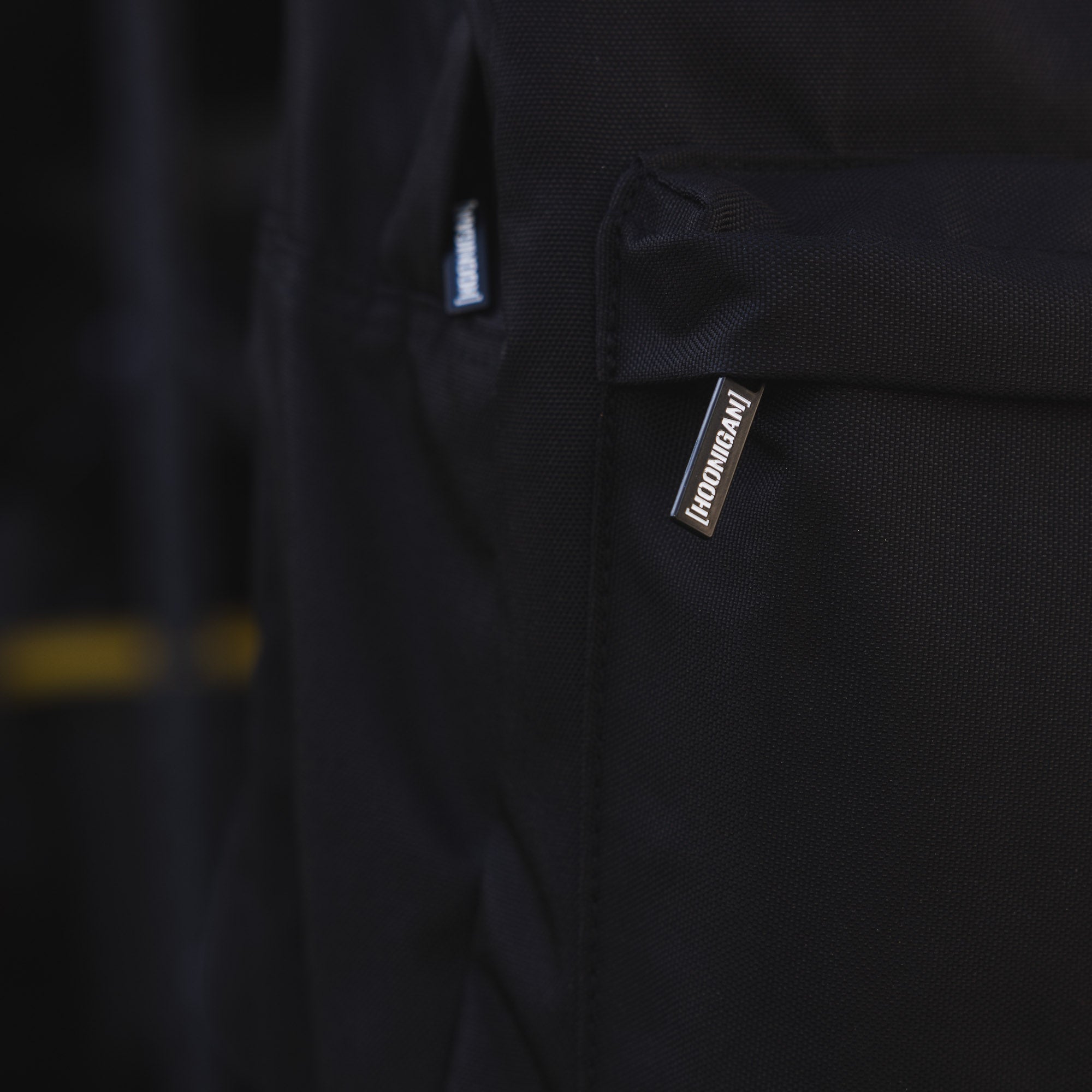 Hoonigan CENSOR BAR Light Backpack featuring a sleek design with a prominent logo, adjustable straps, and multiple compartments for storage.