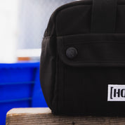 Hoonigan CENSOR BAR Tool Bag featuring a durable black design with multiple pockets and the Hoonigan logo.