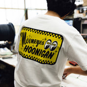Hoonigan x Mooneyes "Go With Hoon" short sleeve tee featuring a bold graphic design in white on a black background.