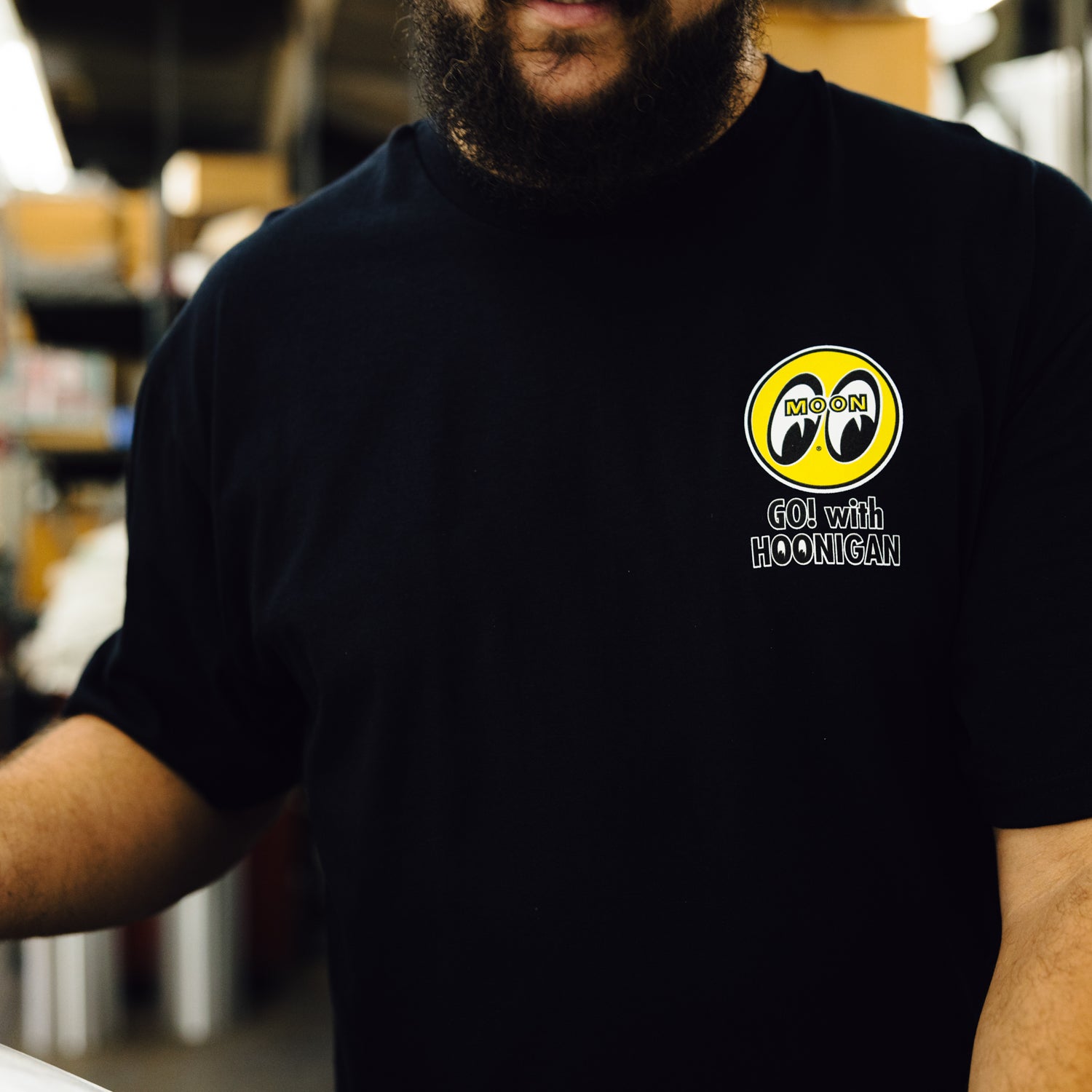 Hoonigan x Mooneyes "Go With Hoon" short sleeve tee featuring a bold graphic design on a black background.