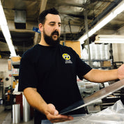 Hoonigan x Mooneyes 'GO WITH HOON' short sleeve tee featuring bold graphic design and logo accents on a black fabric background.