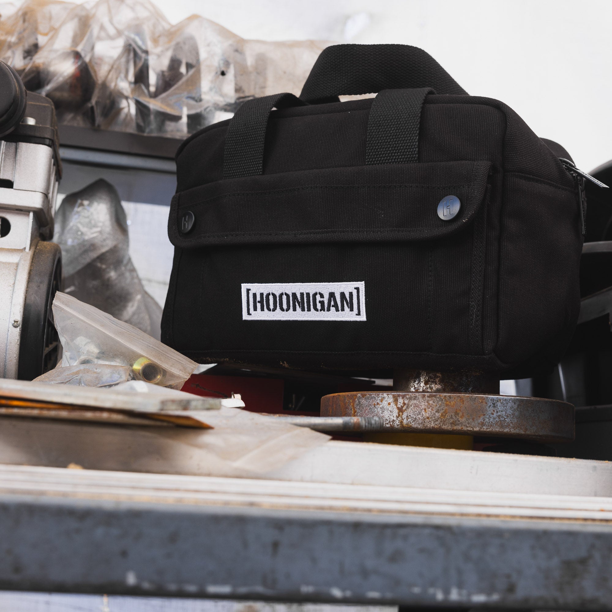 Hoonigan CENSOR BAR Tool Bag in black with white logo, featuring multiple pockets and durable straps for versatile use.