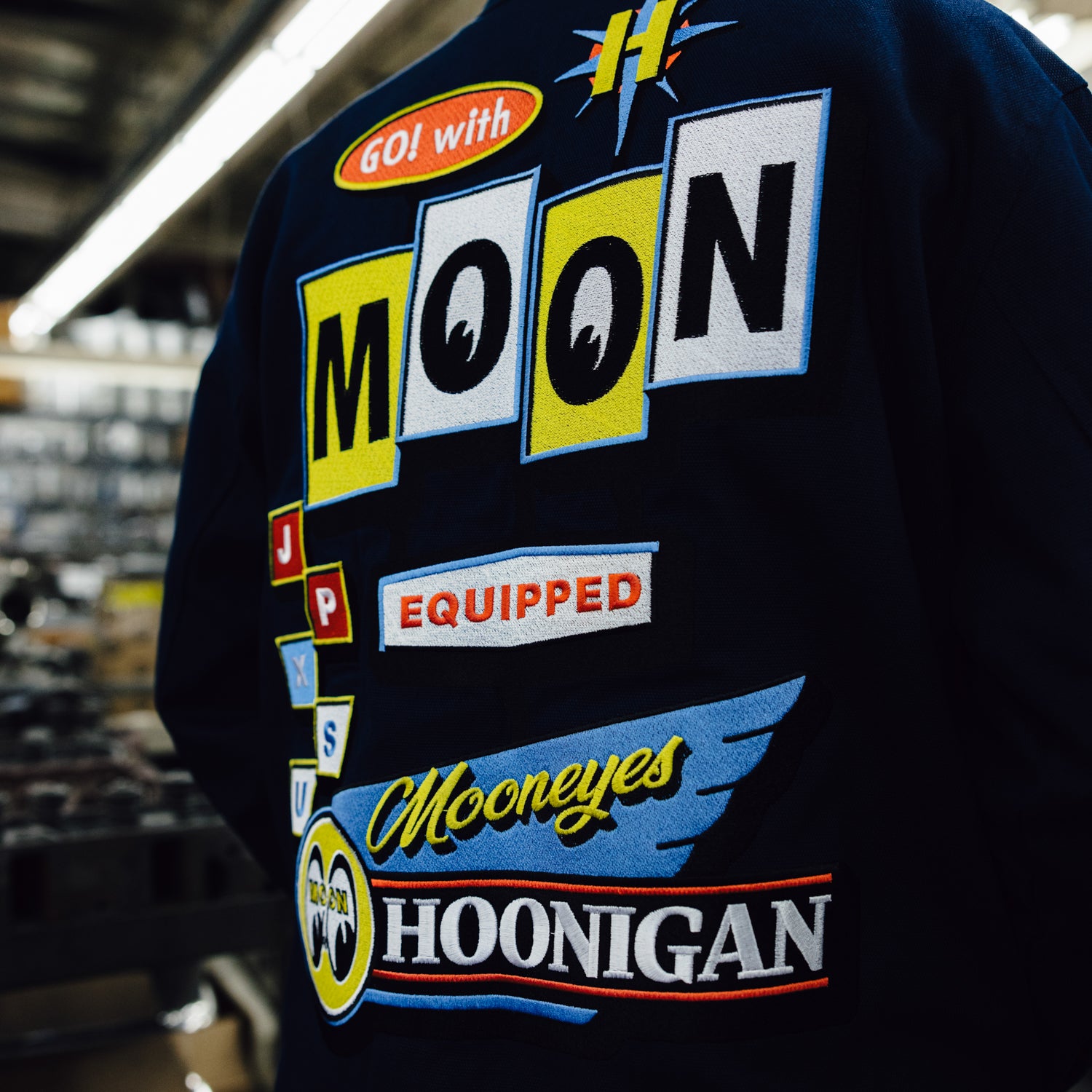 Hoonigan x Mooneyes MOON MOTEL Jacket featuring a bold graphic design, black fabric, and multiple front pockets.