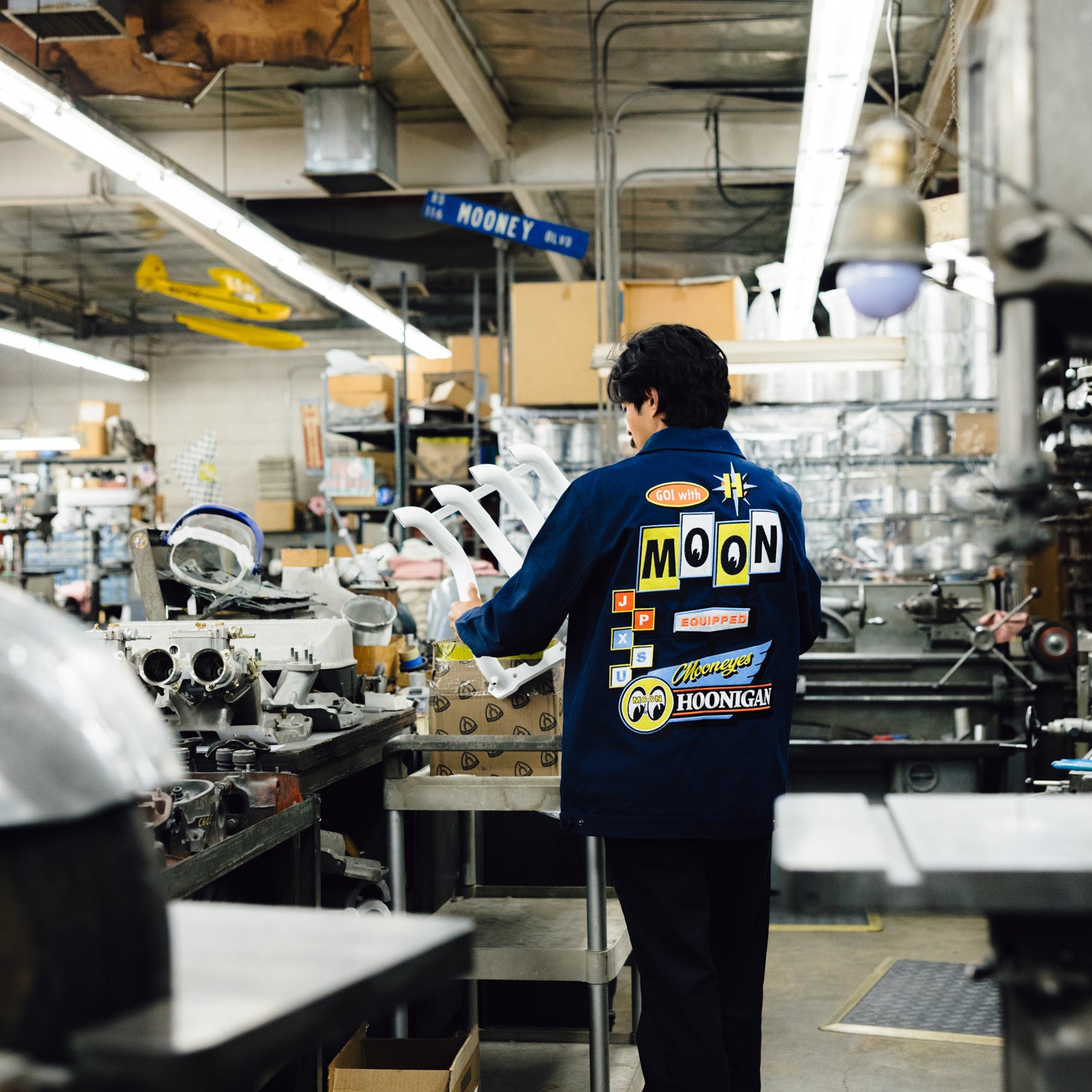 Hoonigan x Mooneyes MOON MOTEL jacket featuring a black design with white graphics and logos.
