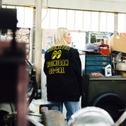 Hoonigan x Mooneyes SO CAL Jacket featuring a black design with vibrant yellow accents and logos on the front and back.