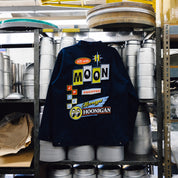 Hoonigan x Mooneyes MOON MOTEL Jacket featuring black fabric, vibrant yellow graphics, and a modern design.
