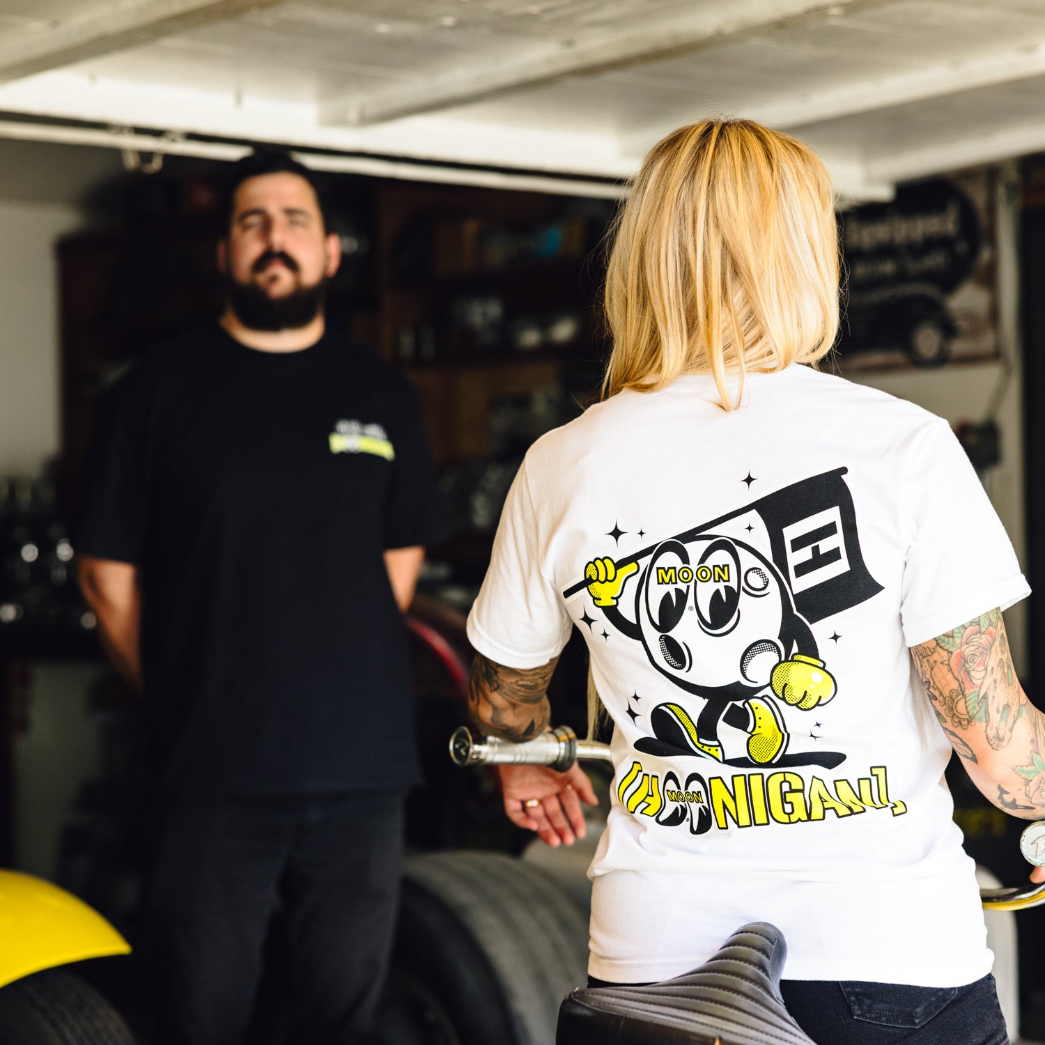 Hoonigan x Mooneyes MASCOT Short Sleeve Tee featuring a graphic logo design on a black fabric background.