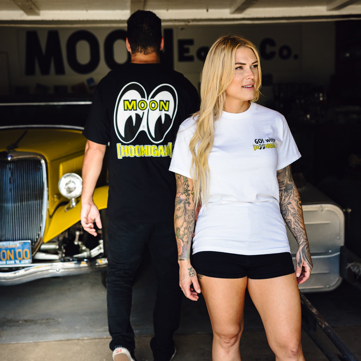 Hoonigan x Mooneyes short sleeve tee featuring a bold graphic print of "HOON AND MOON" in yellow and black on a black background.