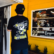 Hoonigan x Mooneyes MASCOT Short Sleeve Tee featuring a vibrant graphic design with a racing theme on a black background.