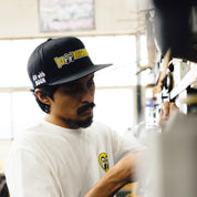 Hoonigan x Mooneyes MOON BAR Snapback Hat in black with white logo and adjustable snap closure.