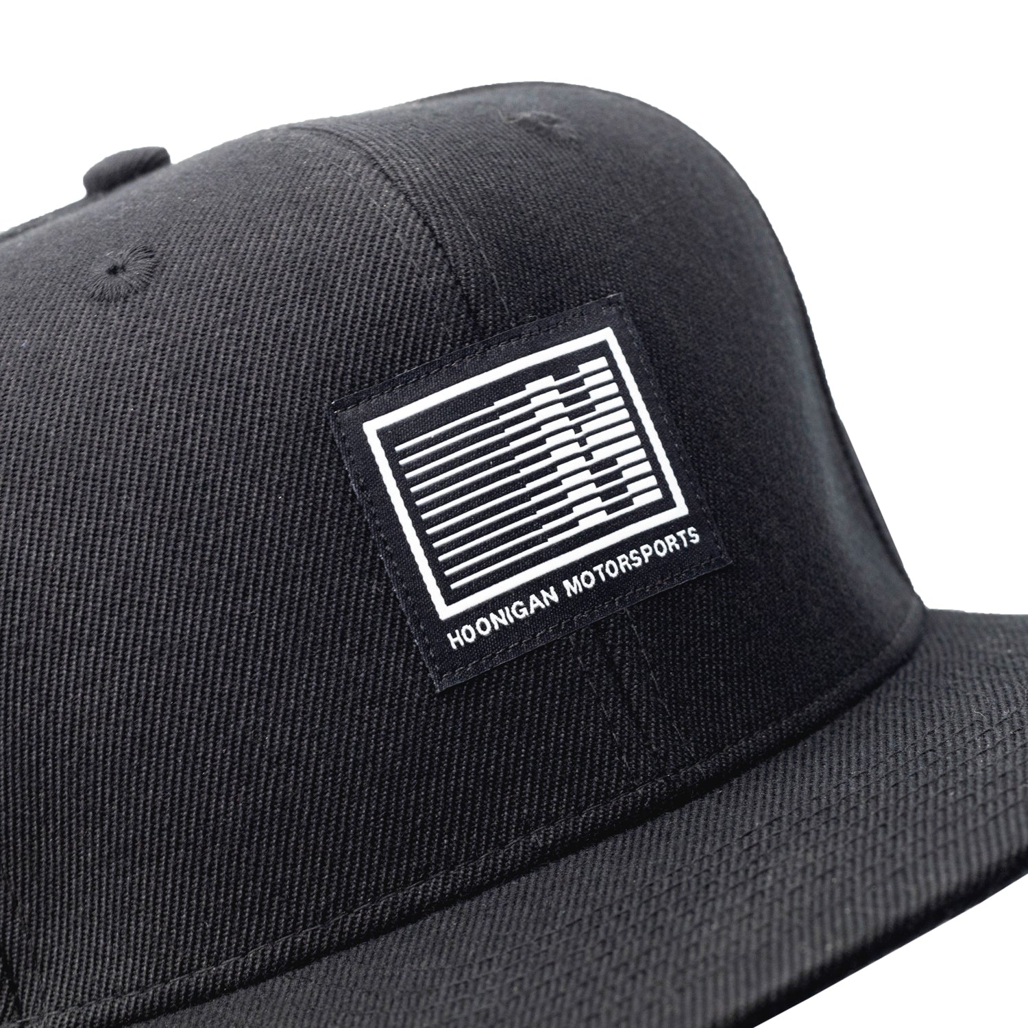 Black Hoonigan Motorsports snapback hat with embroidered logo and adjustable snap closure.