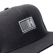 Black Hoonigan Motorsports snapback hat with embroidered logo and adjustable snap closure.