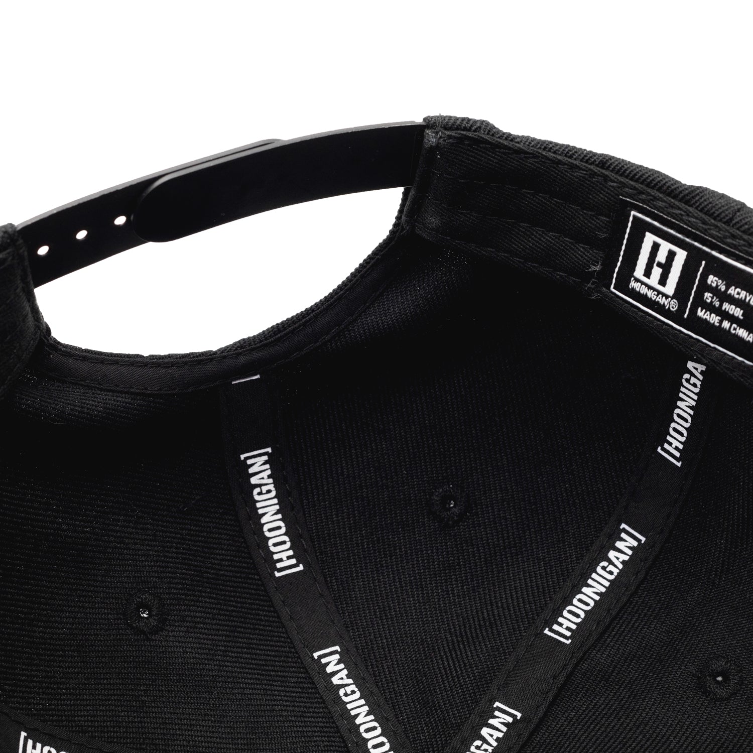 Black Hoonigan Motorsports snapback hat featuring a bold white logo on the front and a flat brim, perfect for automotive enthusiasts.