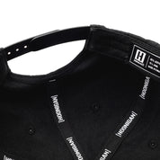 Black Hoonigan Motorsports snapback hat featuring a bold white logo on the front and a flat brim, perfect for automotive enthusiasts.