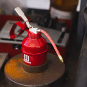 Hoonigan oil can featuring a bold black and white design with a vintage racing aesthetic.