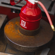Hoonigan branded oil can in black and red with a vintage design, featuring the Hoonigan logo and a spout for pouring.