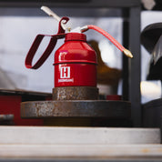 Hoonigan oil can with a black and white design featuring the Hoonigan logo and a durable handle.