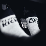 Hoonigan NEVER LIFT socks featuring a bold black design with white text, ideal for motorsport enthusiasts.
