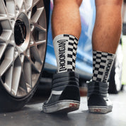Black Hoonigan NEVER LIFT socks featuring bold white logos and a stylish design, perfect for motorsport enthusiasts.