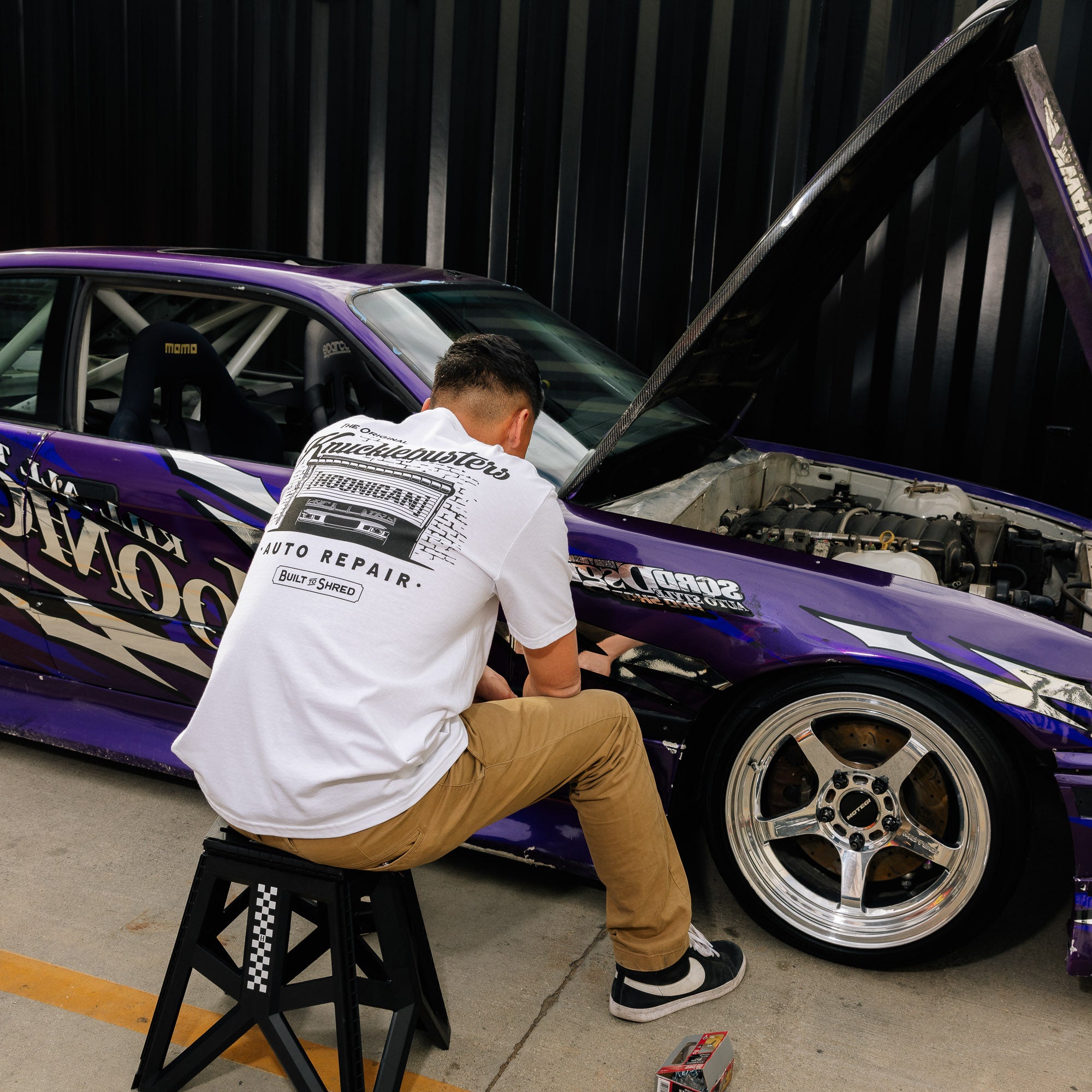 Hoonigan KNUCKLEBUSTERS AUTO REPAIR black short sleeve t-shirt featuring a graphic design of a wrench and automotive elements.