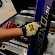 Hoonigan KNUCKLEBUSTERS gloves featuring a black and white design with padded knuckles and reinforced stitching.