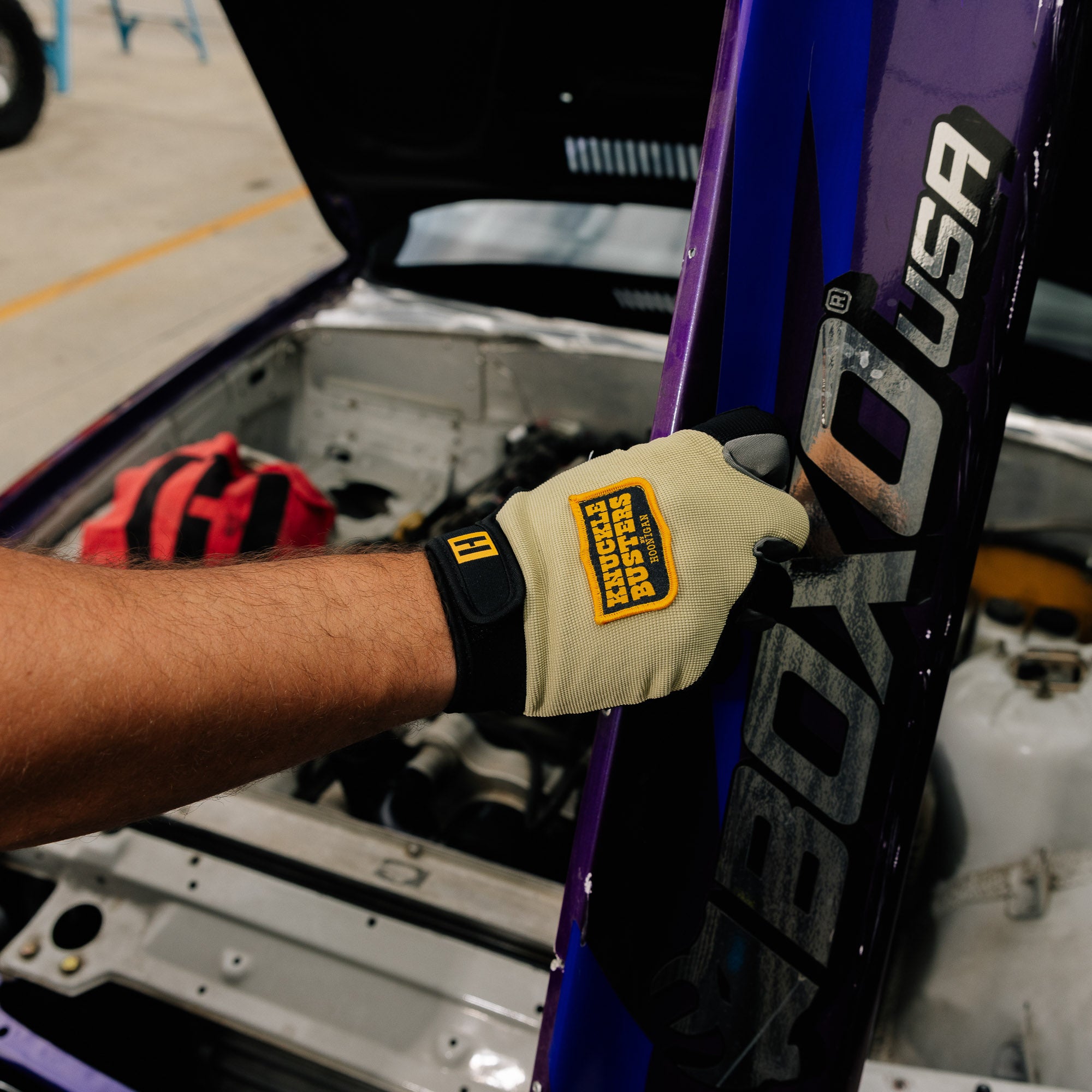 Hoonigan KNUCKLEBUSTERS gloves featuring a black and white design with padded knuckles and reinforced stitching.