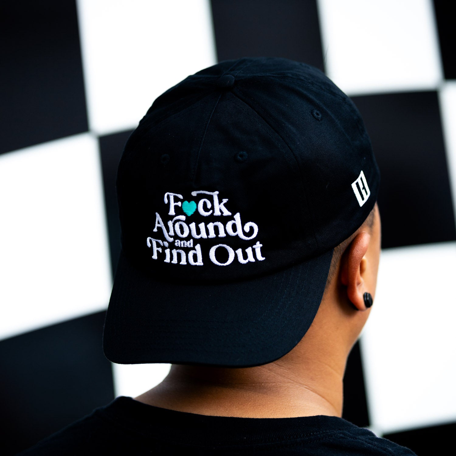 Hoonigan FIND OUT unstructured strapback hat featuring a black canvas design with bold white logo embroidery on the front.