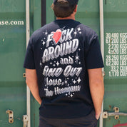 Back view of a person wearing a black Hoonigan FIND OUT V2 Short Sleeve Tee with bold graphic text and star designs on the back.