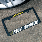Hoonigan PARKING LOT CHAMPIONS License Plate Frame featuring a bold black design with the words "PARKING LOT CHAMPIONS" in white lettering.
