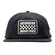 Black unstructured snapback hat featuring a checkerboard patch with "Hoonigan Industries" embroidered on the front.