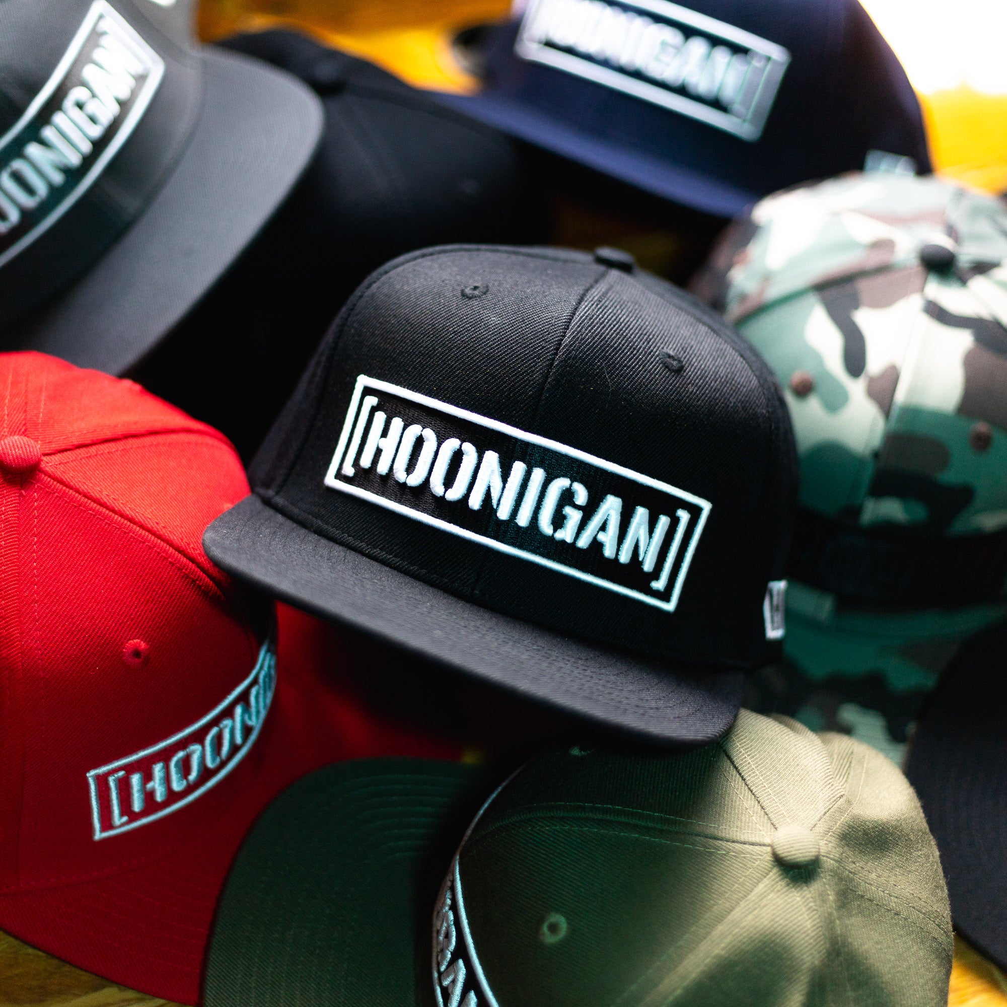 Hoonigan CENSOR BAR Snapback Hats in various colors stacked together, featuring bold embroidered logo on the front.