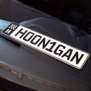 Hoonigan EURO license plate featuring bold lettering and a checkered flag design, perfect for car enthusiasts.