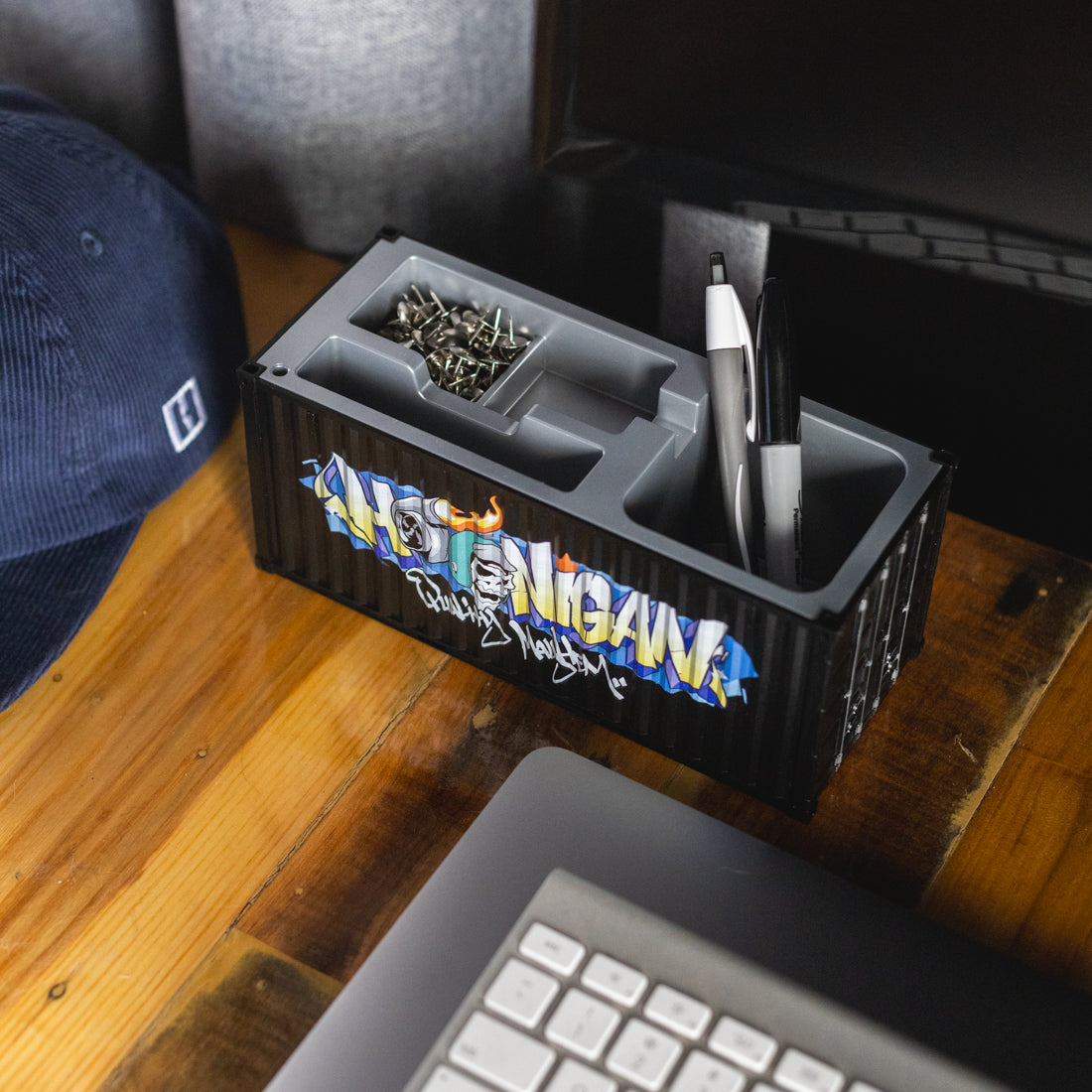 Hoonigan X Spen1 mini shipping container in vibrant colors, showcasing graffiti-style artwork and intricate designs.