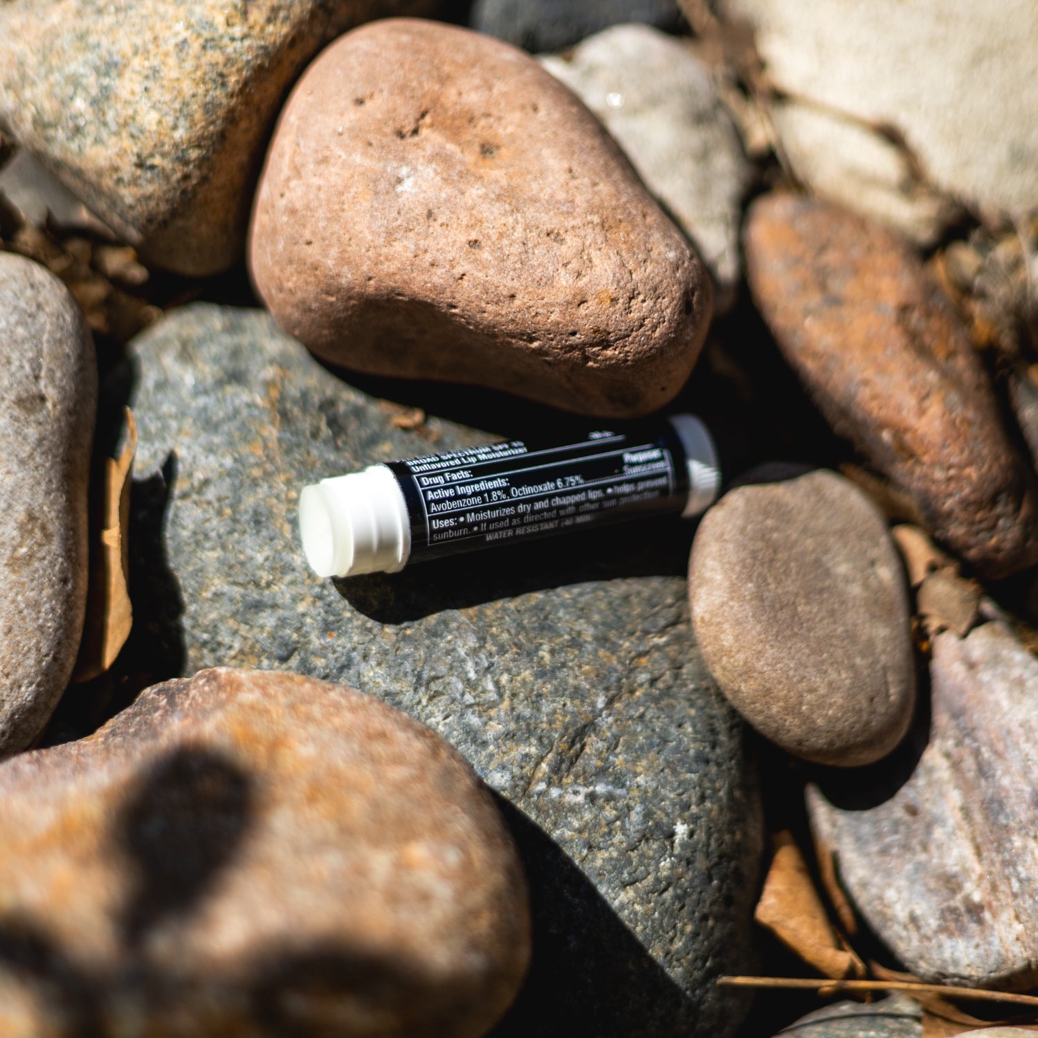 Black Rhino LIP ARMOR lip balm in a sleek container, featuring a black design with the product name prominently displayed.