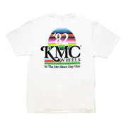 White KMC DAY ONE short sleeve tee featuring a colorful graphic design with "82" and "KMC Wheels" logo, and "In The Dirt Since Day One" text.
