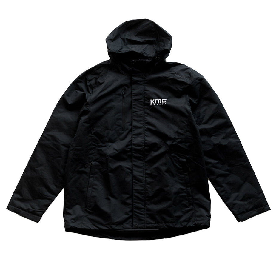 Black KMC jacket with a sleek design and zip closure, featuring two side pockets and a subtle logo on the chest.
