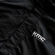 KMC Jacket featuring a sleek black design with a high collar and zippered front, suitable for both outdoor and casual wear.