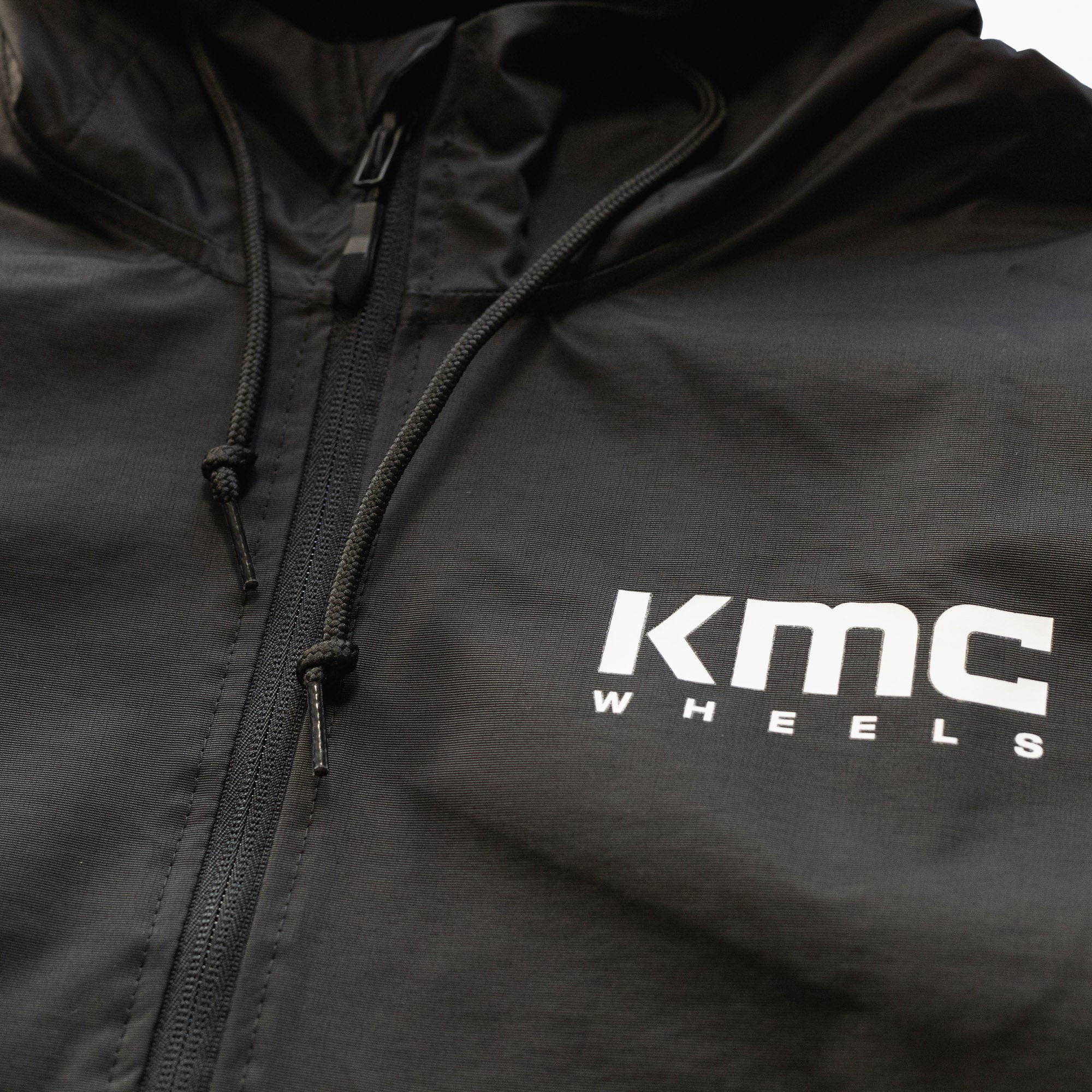KMC Wheels V2 Half Zip Anorak Jacket in black, featuring a pullover design, half zip closure, and adjustable hood.