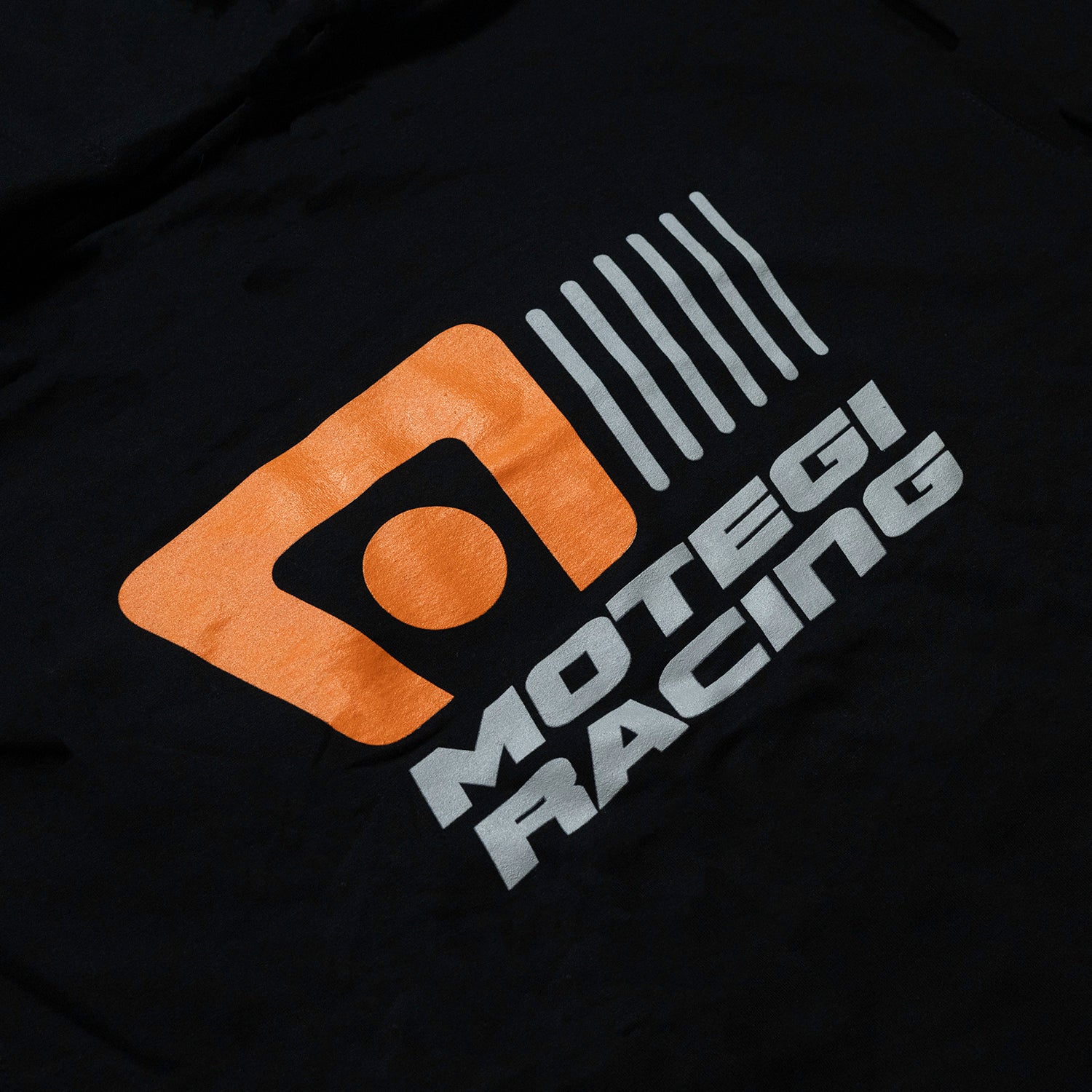 Motegi Racing logo hoodie featuring a bold graphic design in black on a light gray background.