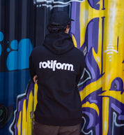 Rotiform STAPLE hoodie in black and white, featuring a prominent Rotiform logo on the back, displayed in a lifestyle setting.
