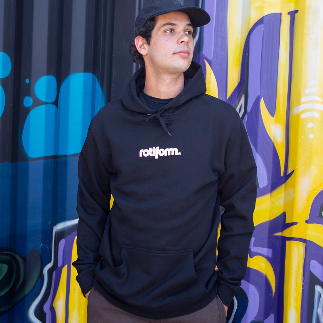 Black and white Rotiform STAPLE hoodie featuring a front logo design, modeled casually in a lifestyle setting.