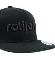 Rotiform STAPLE Snapback Hat in black with embroidered logo detail on the front.