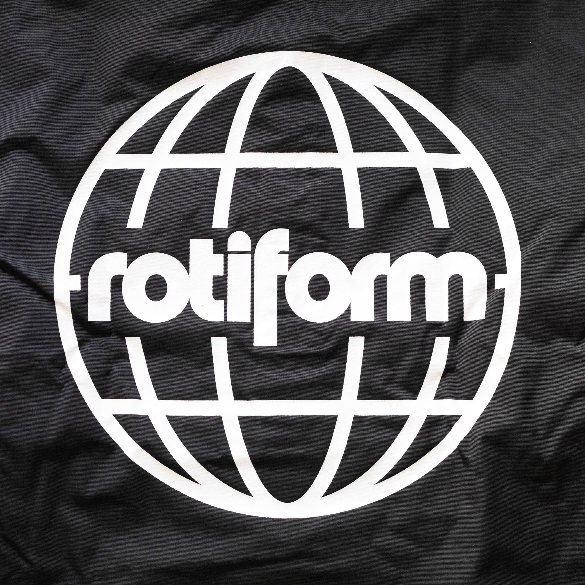 Black Rotiform GLOBAL IMPACT half-zip anorak jacket with a white globe logo and "rotiform" text on the front.