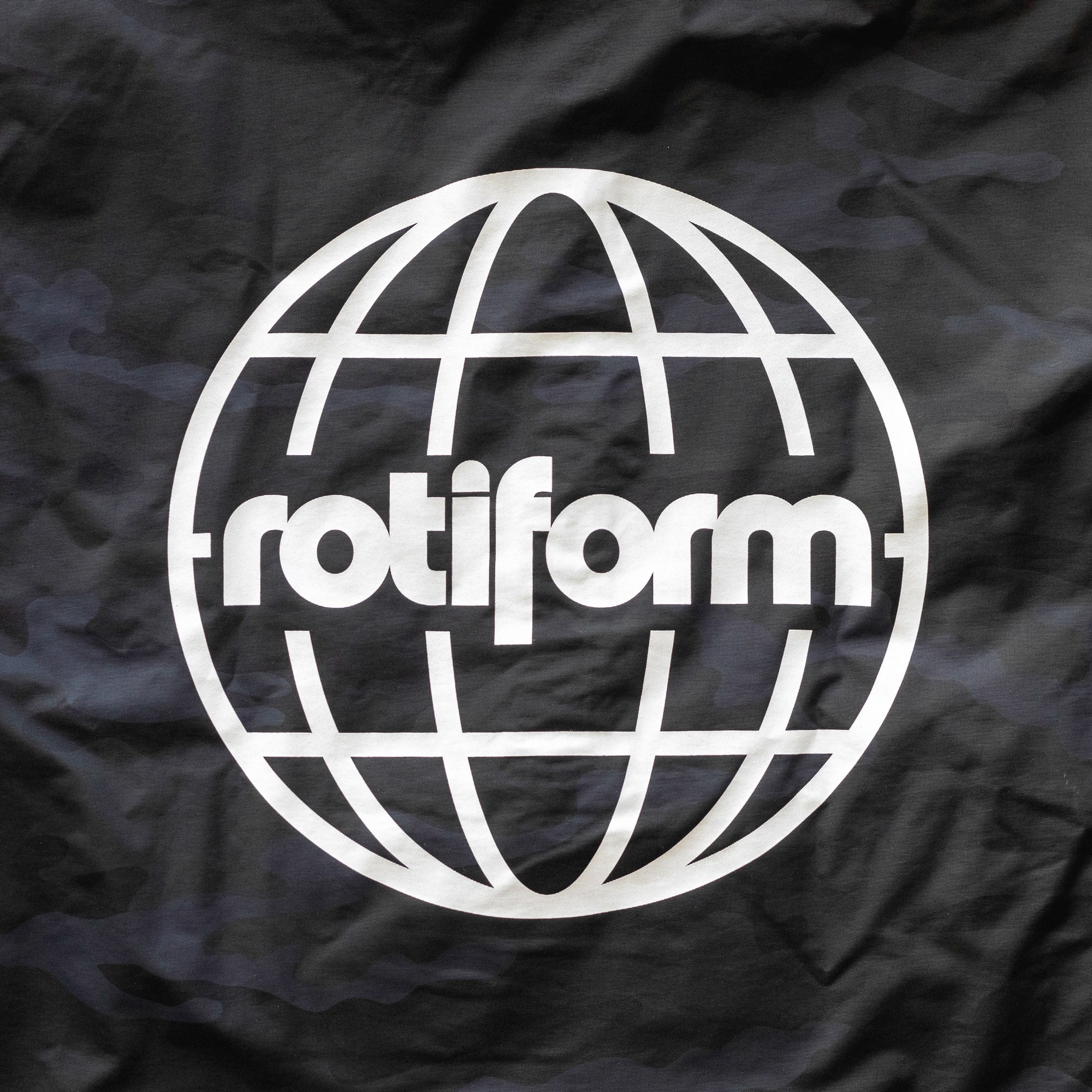 Black Rotiform GLOBAL IMPACT half zip anorak jacket with a white globe logo and "rotiform" text on the front.